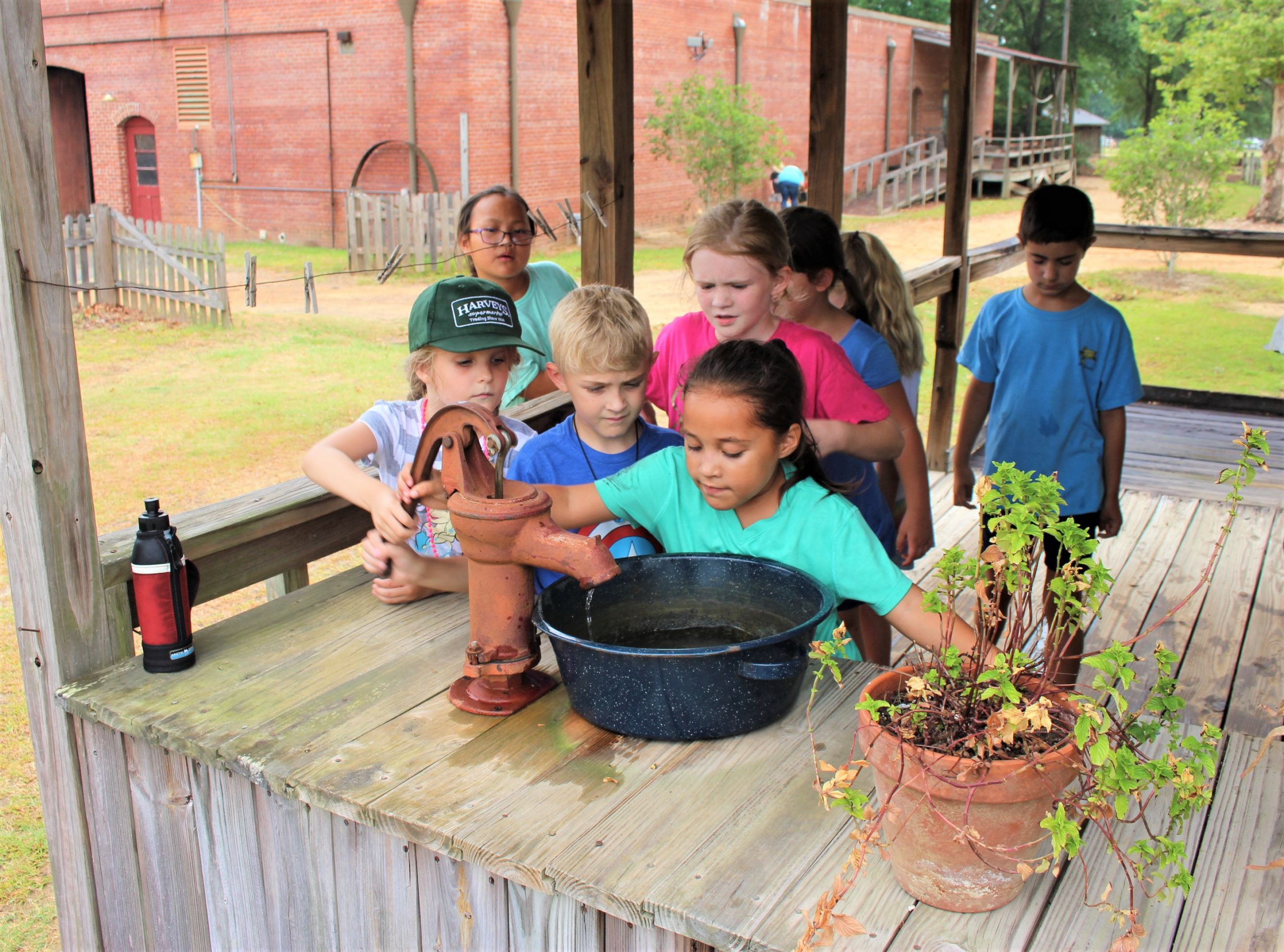 kids washing hands at the water well