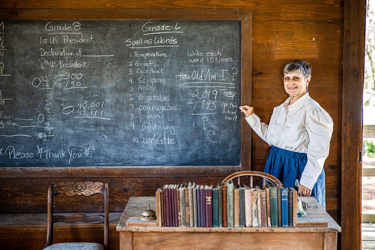 teaching interpreter standing in front of a chalk board