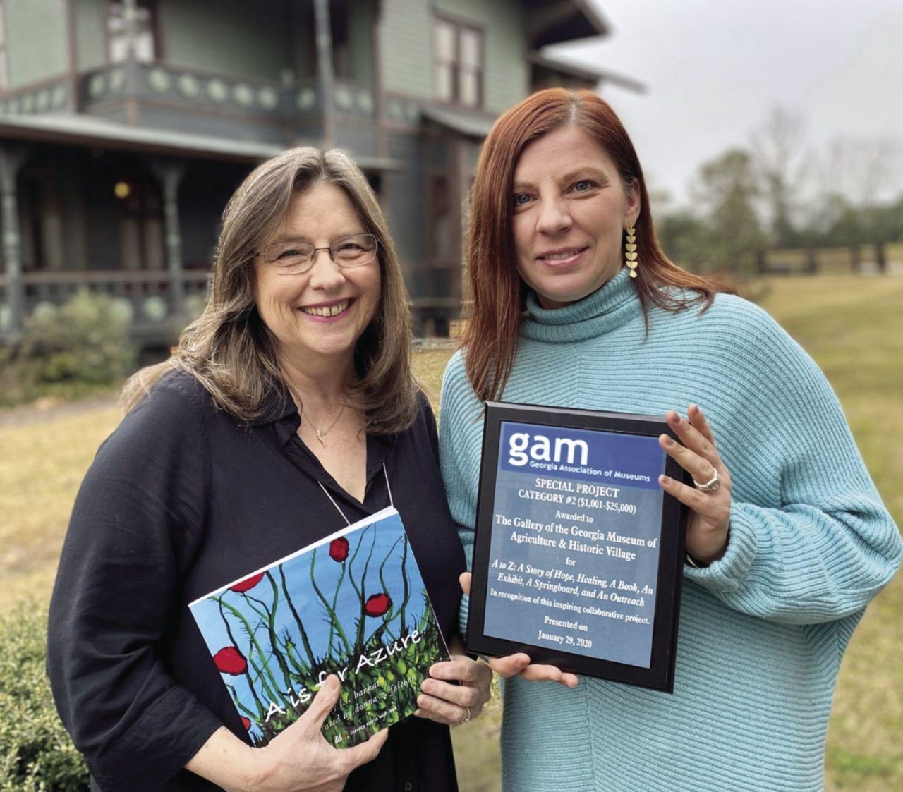 Donna Falcone (left) and Polly Huff with the GAM award for “A to Z.”